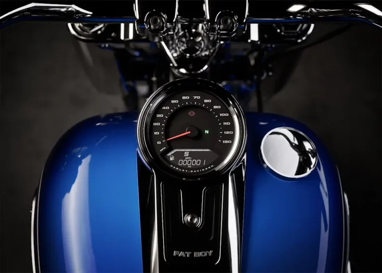 Detailaufnahme des Tachometers einer blauen Harley-Davidson Fat Boy mit sichtbarem Geschwindigkeitsmesser und Tank.