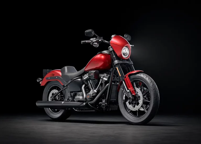 Ein rotes Harley-Davidson-Motorrad steht auf einem dunklen Hintergrund und präsentiert sein markantes Design.