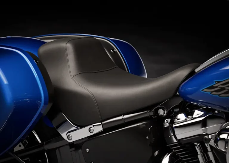 Nahaufnahme des schwarzen Motorrad-Sitzes einer Harley-Davidson mit blauen Verkleidungsteilen auf einem dunklen Hintergrund.