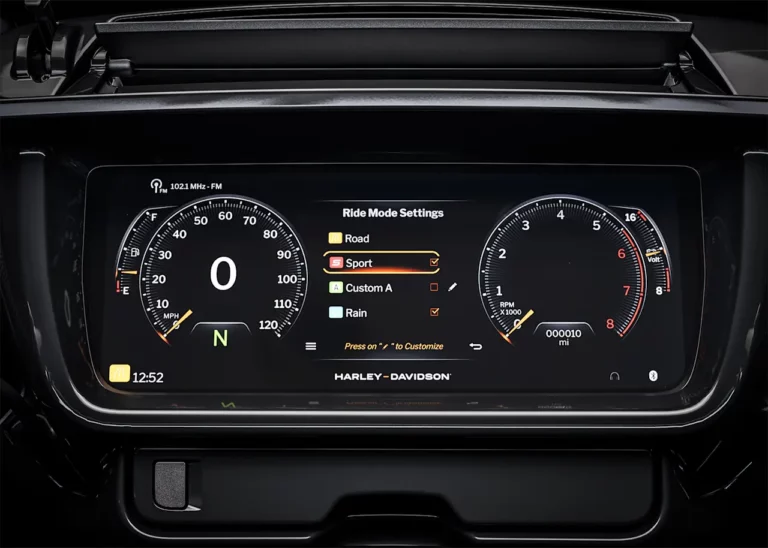 Das digitale Cockpit eines Harley-Davidson-Motorrads zeigt die Geschwindigkeits- und Drehzahlanzeige sowie die verschiedenen Fahrmodi wie Sport, Custom A, und Regen.