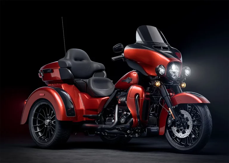 Ein rotes Harley-Davidson Motorrad mit Beiwagen steht vor einem dunklen Hintergrund.