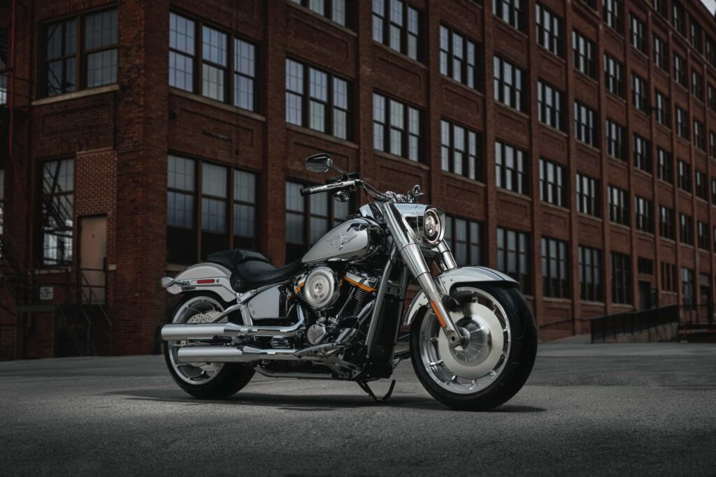 Eine glänzende Harley-Davidson-Motorrad steht vor einem historischen Backsteingebäude, das die zeitlose Eleganz und Kraft der Marke verkörpert.