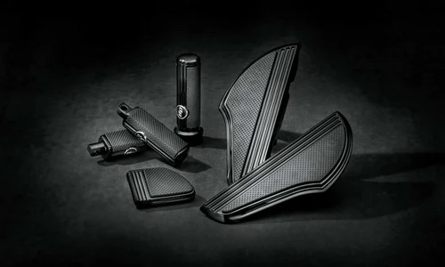 Schwarze Motorrad-Zubehörteile für Harley-Davidson, darunter Griffe und Abdeckungen, auf dunklem Hintergrund.