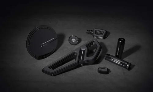 Verschiedene hochwertige Harley-Davidson Motorradteile und Zubehörteile auf einem dunklen Untergrund.