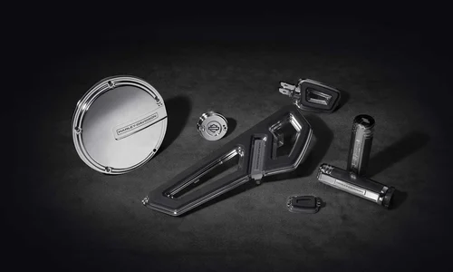 Eine Auswahl an hochwertigen Harley-Davidson Ersatzteilen und Zubehör in glänzendem Metallfinish auf dunklem Hintergrund.