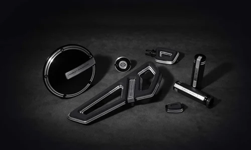 Verschiedene hochwertige Harley-Davidson Motorradzubehörteile in Schwarz und Silber auf einem dunklen Hintergrund.