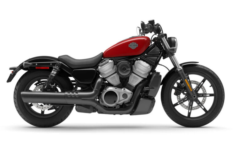 Die Harley-Davidson mit rotem Tank und sportlichem Design präsentiert sich seitlich, bereit für unvergessliche Fahrten auf der Straße.
