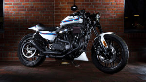 Ein stilvolles Harley-Davidson Motorrad in schwarz-weißer Lackierung steht vor einer Backsteinwand und beleuchtet die Details des Designs.