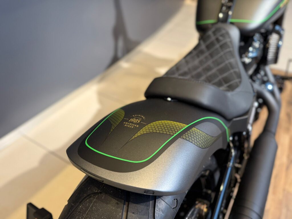Detailaufnahme eines Harley-Davidson Motorrads mit einem sportlichen Sitz und auffälligem Design in Schwarz und Grün.
