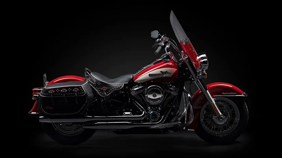 hgr-perform-mcar-4 Eine glänzende rote Harley-Davidson-Motorrad mit chromfarbenen Akzenten vor schwarzem Hintergrund.